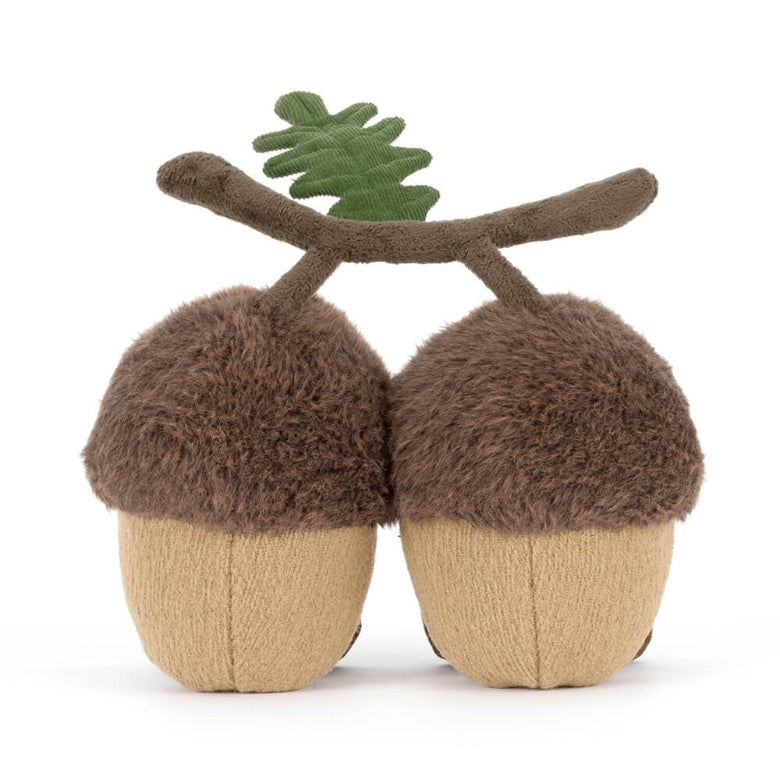 Stuffed acorn toy with a branch on a white background