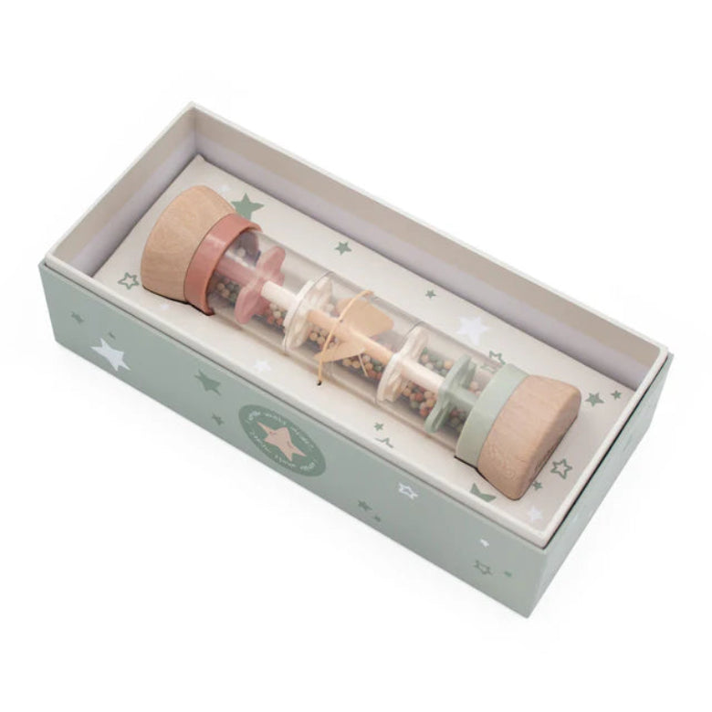 Wooden toy with a clear tube filled with small objects, housed in a decorative box with star patterns.