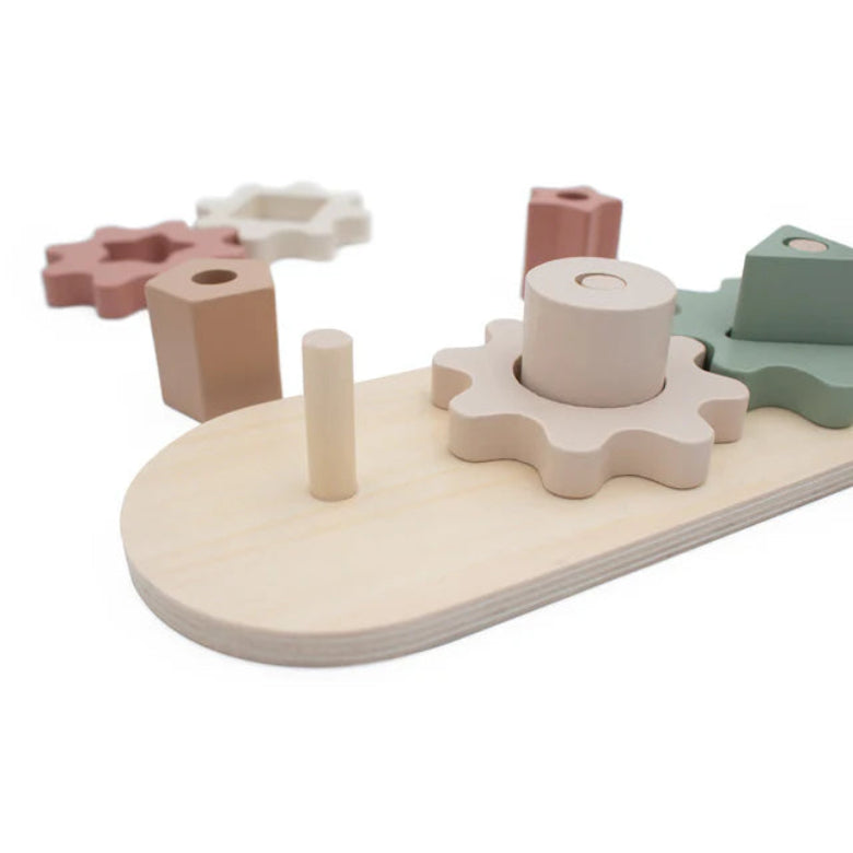 Wooden shape sorting toy with various geometric blocks on a white background