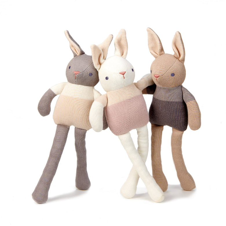 Three plush rabbit toys in different colors on a white background