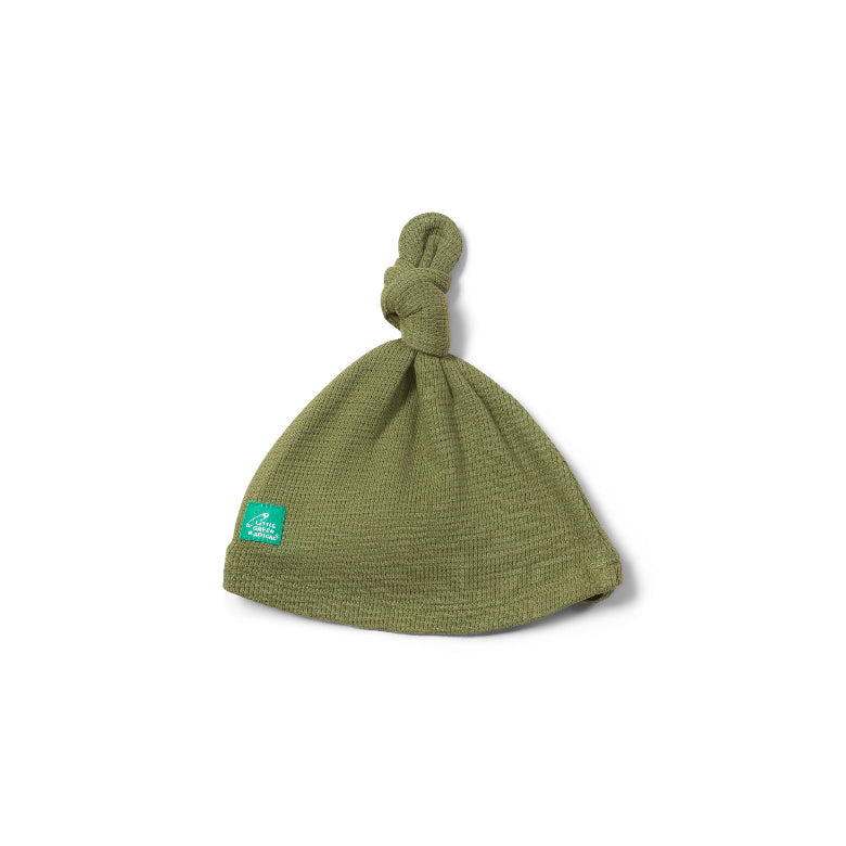 Green knotted baby hat on a white background