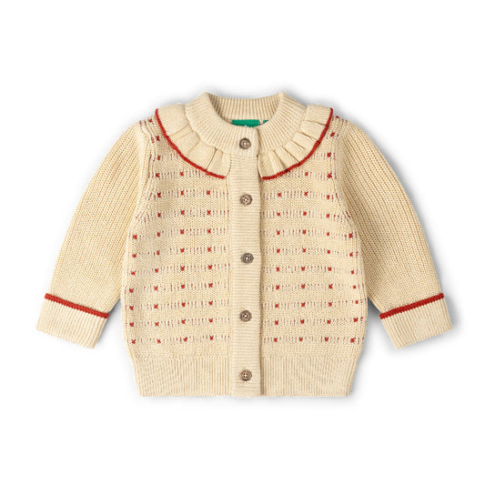 A cream-colored baby knit cardigan sweater with a ruffled Peter Pan collar, button closure, and red trim details on the collar, cuffs, and body pattern, shown on a plain white background.