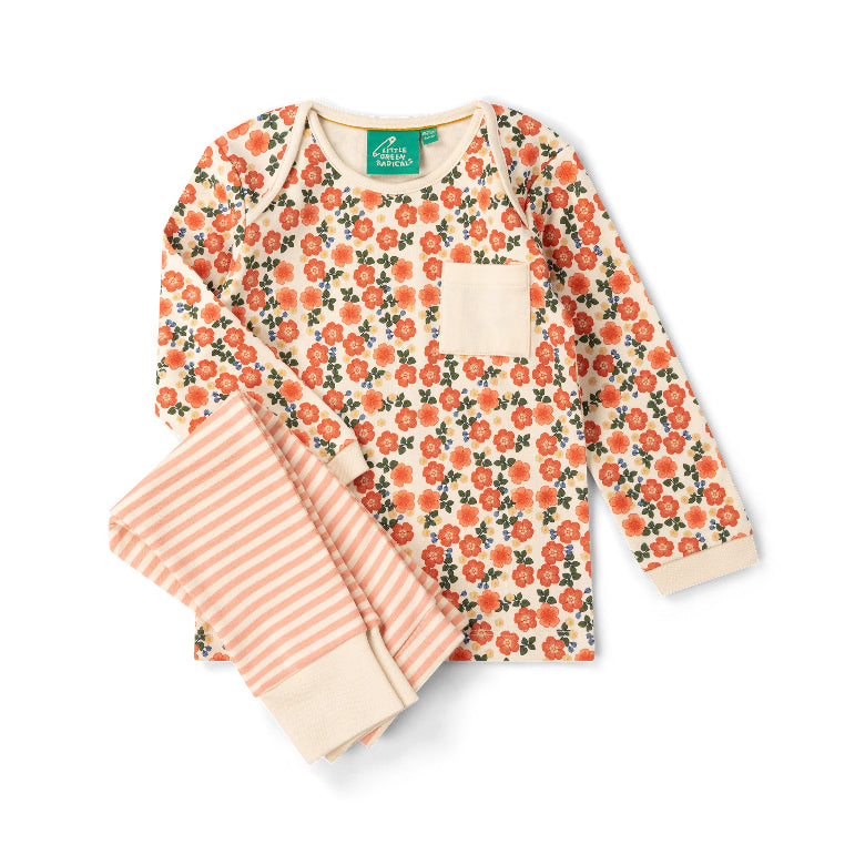 A two-piece baby pajama set by The Happy Sleeper, featuring a long-sleeve top with a coral-orange and green floral print on a cream background, and matching striped pants in coral and cream.