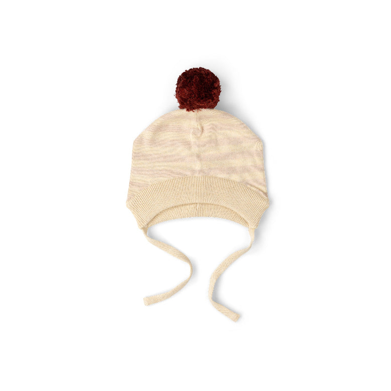 A cream-colored knit baby hat with subtle horizontal stripes, featuring a dark red pom-pom on top and matching tie strings, shown against a plain white background.