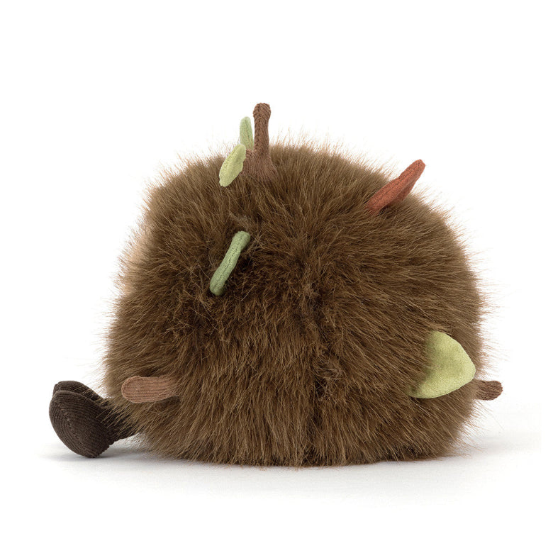 Plush toy resembling a brown creature with green antennae on a white background