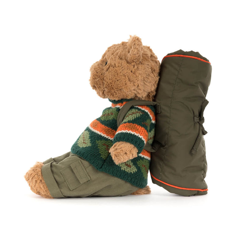 Teddy bear wearing a sweater and carrying a backpack on a white background