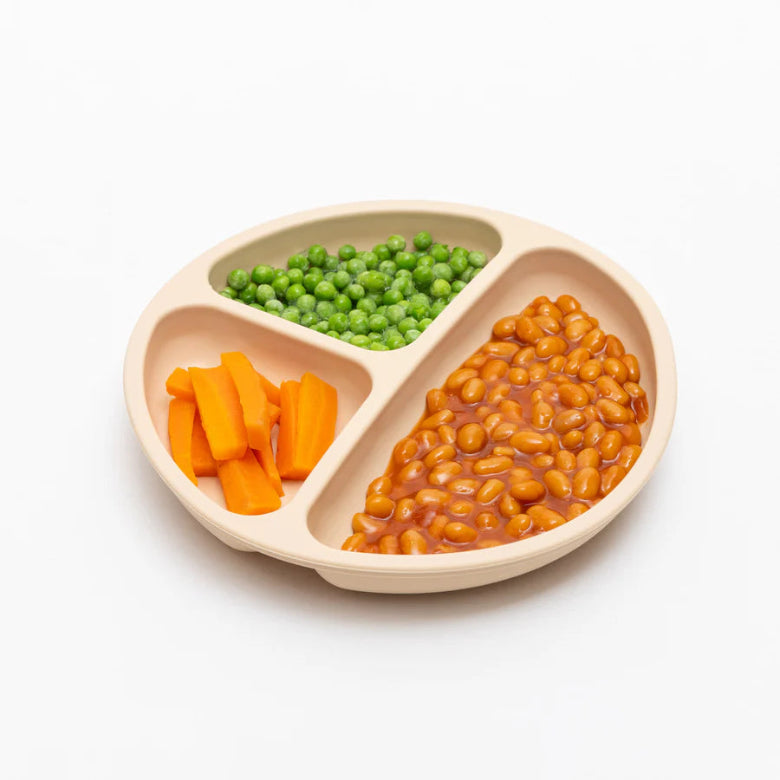 Three-section plate with carrots, peas, and beans on a white background