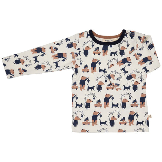 A long-sleeve baby t-shirt with an all-over cartoon dog and bear pattern on an off-white background, featuring a dark navy blue crew neck collar.