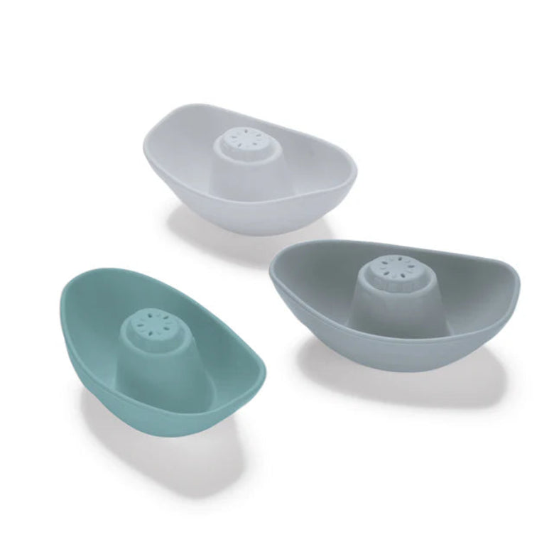 Three boat-shaped silicone sieves in different colors on a white background