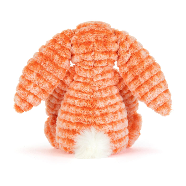 An orange ribbed plush bunny toy shown from the back, featuring long floppy ears and a white fluffy tail, photographed on a clean white background.