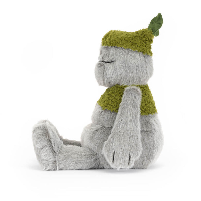 Plush toy with a green hat and scarf on a white background