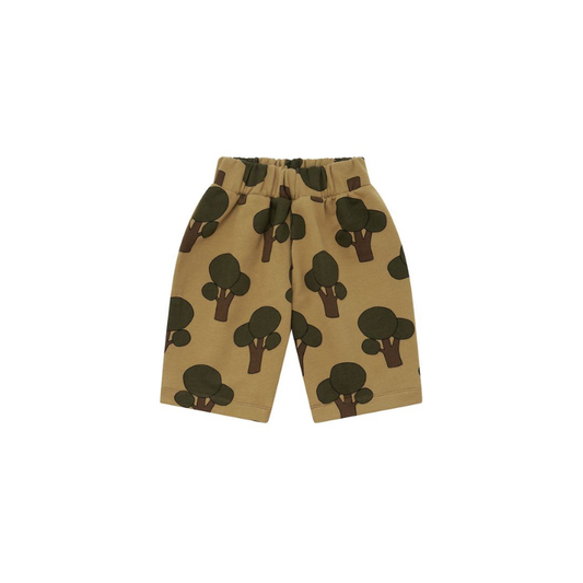 A pair of toddler shorts in a warm tan color, featuring an all-over print of dark green and brown tree silhouettes, shown against a plain white background.