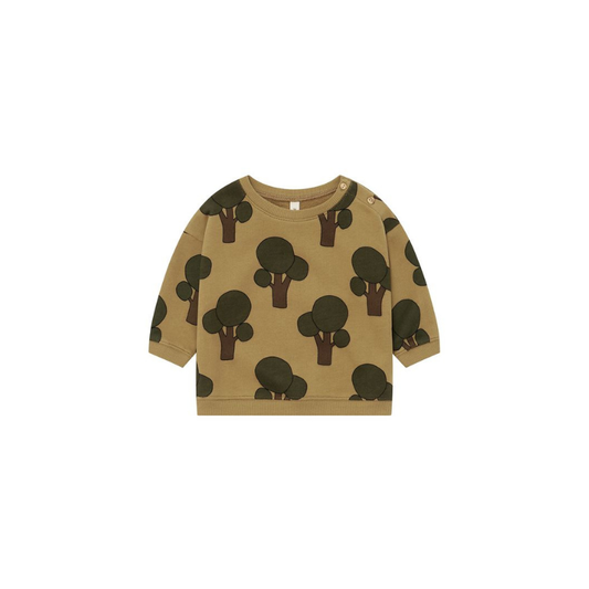 A toddler's long-sleeve crewneck sweatshirt in a warm tan color, featuring an all-over print of dark green and brown tree silhouettes, shown flat on a white background.