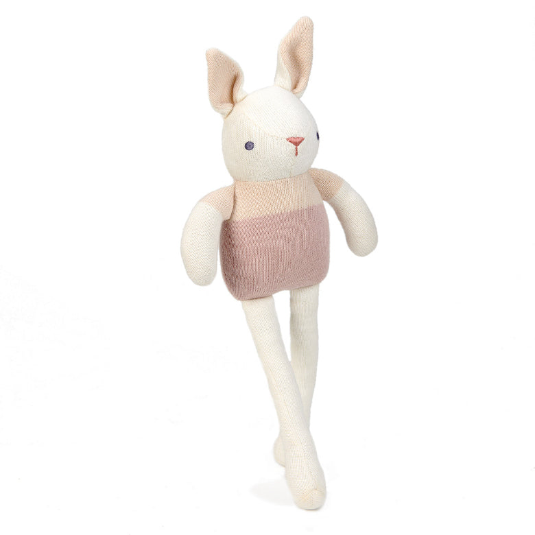 Stuffed rabbit toy with a pink sweater on a white background