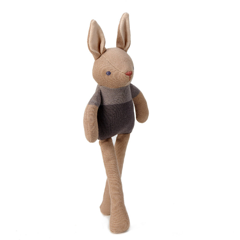 Stuffed rabbit toy with a sweater on a white background